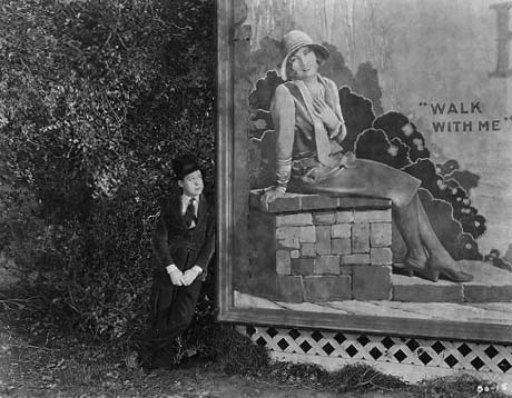 1926, 'Tramp, Tramp, Tramp.' Harry admires 'Betty' (Joan) on a billboard.