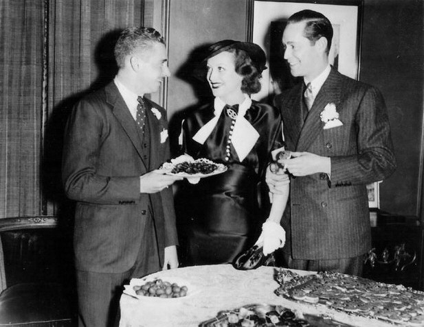 Circa 1935. With husband Franchot Tone (right) at party for the couple hosted by Walter P. Chrysler, Jr. (left).