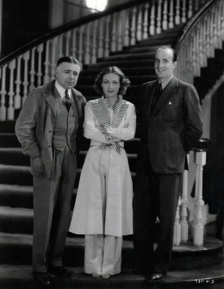 1934. On the set of 'Sadie McKee' with director Clarence Brown, left.