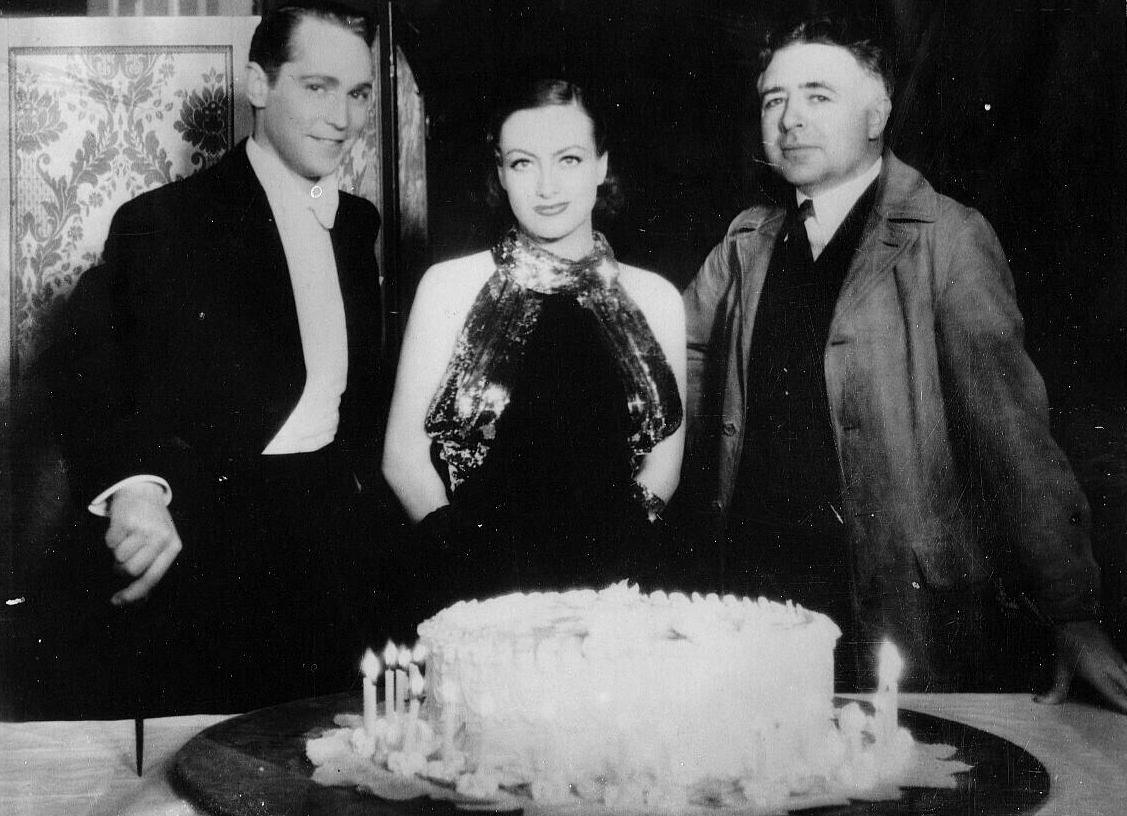 1934. On the set of 'Sadie McKee' with Franchot Tone and director Clarence Brown.