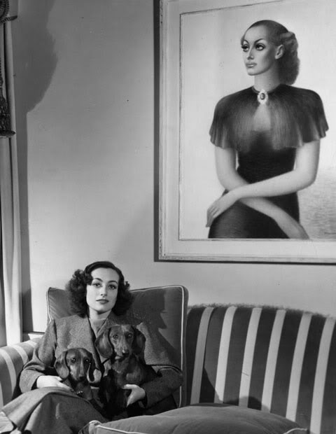 1936. Joan at home, with painting by Edward Biberman.