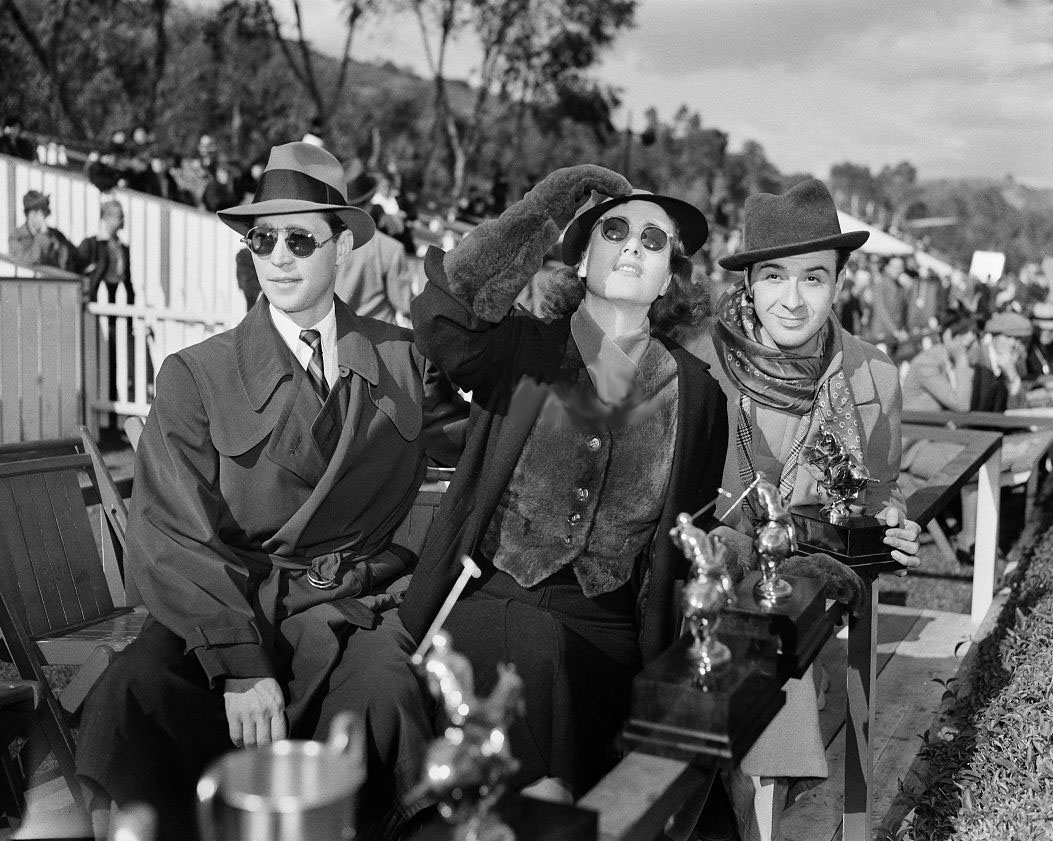 November 1936. At a Los Angeles polo match with husband Franchot Tone, left.