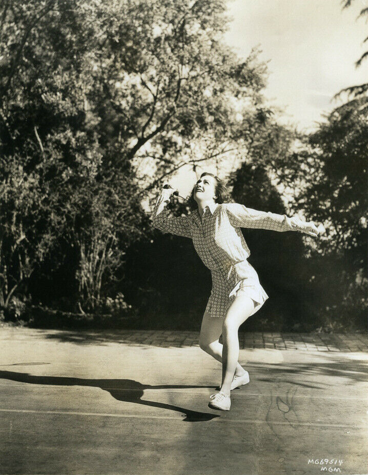 1938. Playing badminton at home.