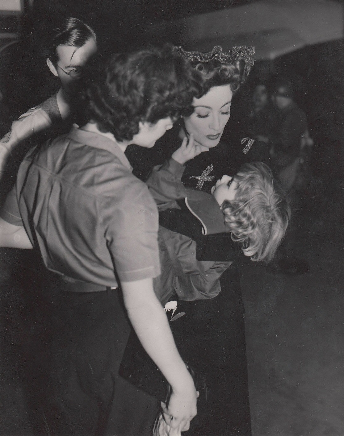 1942. On the set of 'Reunion in France' with a child from the cast.