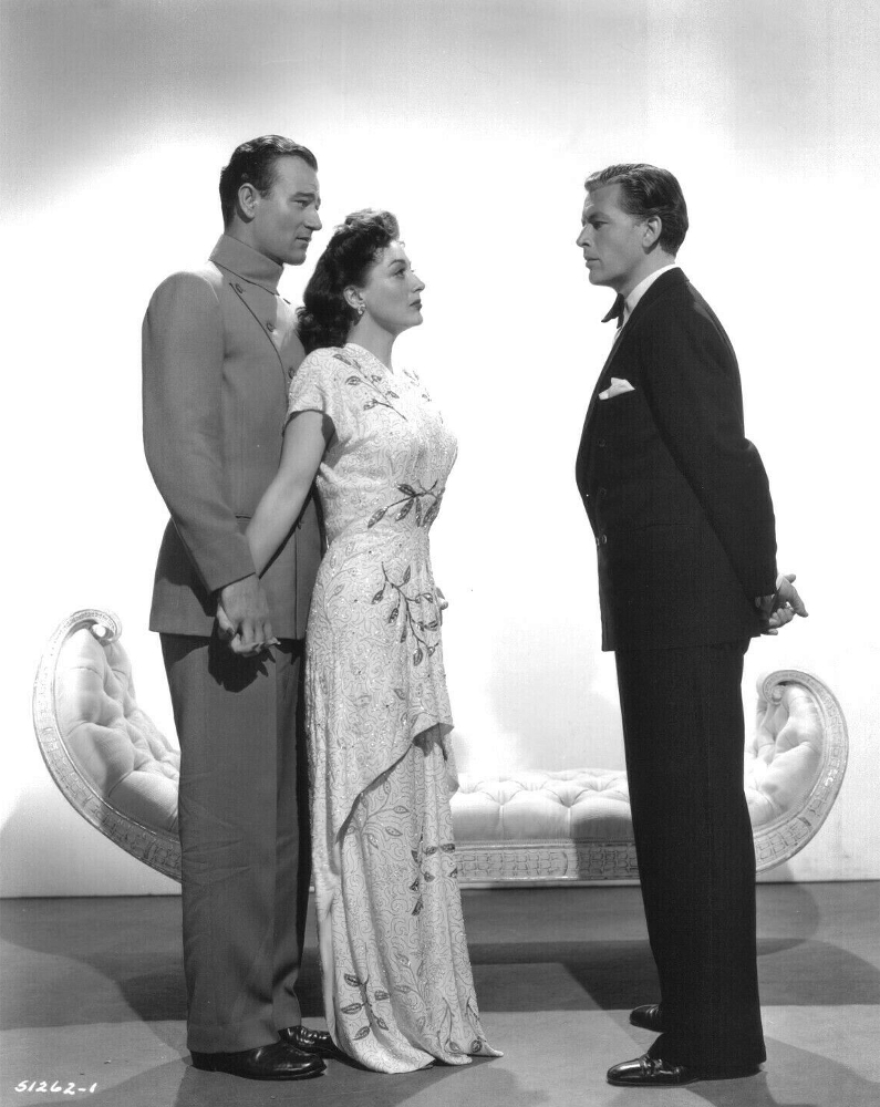 1942. 'Reunion in France' publicity with John Wayne and Philip Dorn.