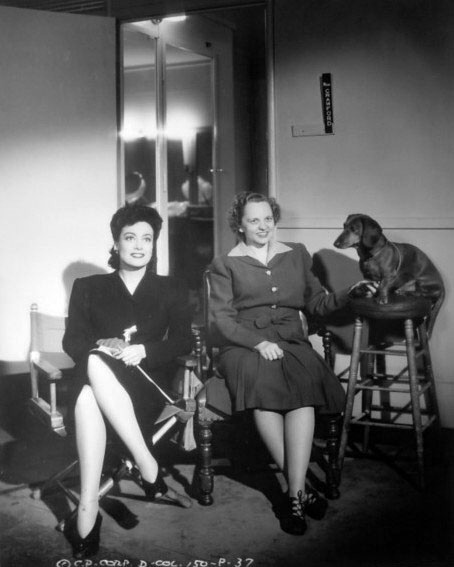 1942. On the set of 'They All Kissed the Bride' with secretary Almeda Dewey.