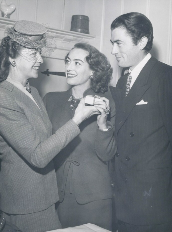 December 1945. With Gregory Peck, receiving the Golden Apple award from the Hollwyood Women's Press Club's Kay Proctor.