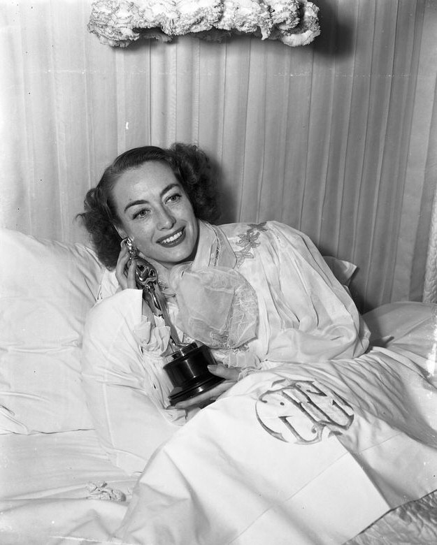 3/7/46. At home with her new Oscar for 'Mildred Pierce.'