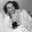 3/7/46. At home with her new Oscar for 'Mildred Pierce.'