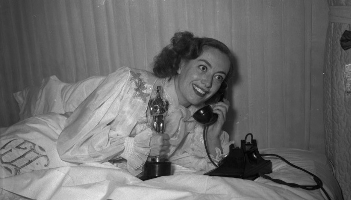 3/7/46. At home with her new Oscar for 'Mildred Pierce.'