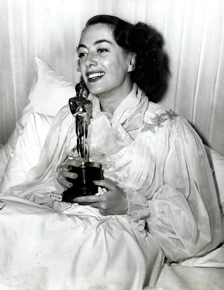 3/7/46. At home receiving Oscar for 'Mildred Pierce.'