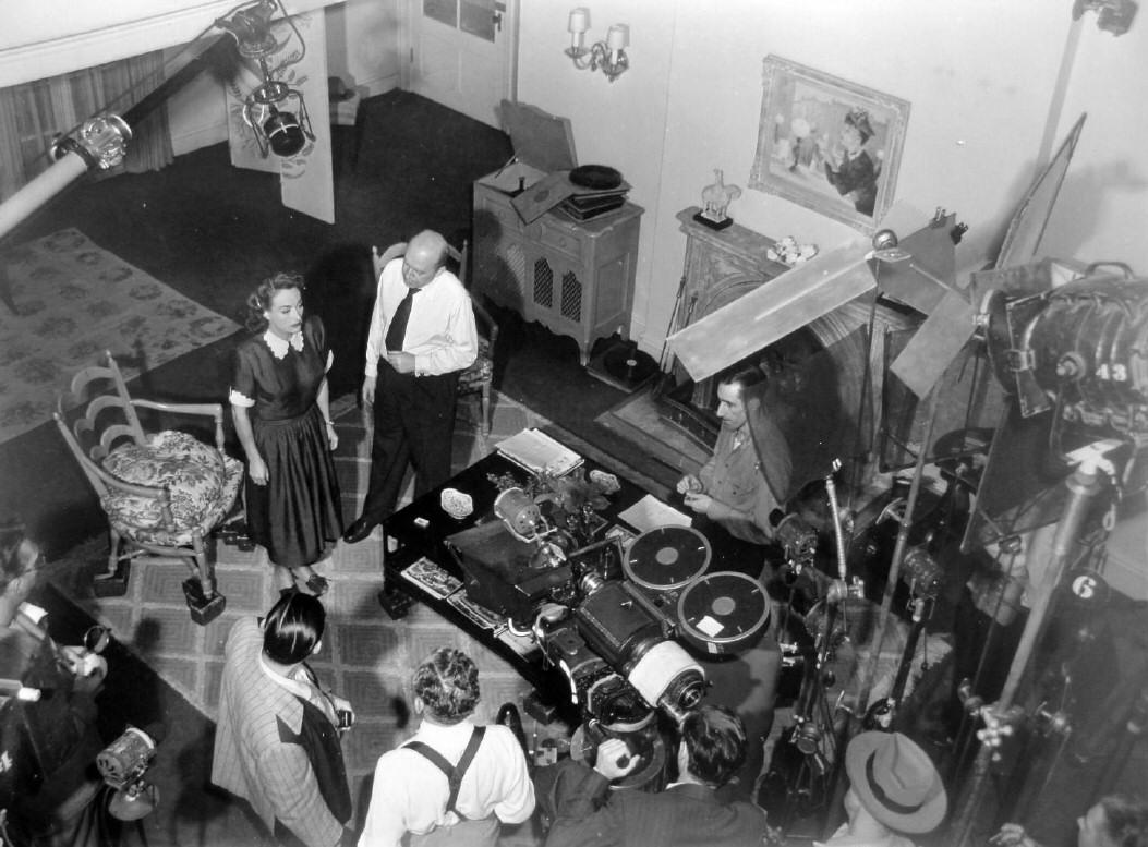 1947. On the set of 'Daisy Kenyon' with director Otto Preminger and crew.