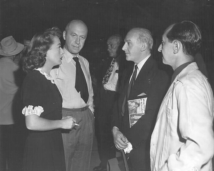 1947. On the set of 'Daisy Kenyon' with director Preminger and Walter Winchell.