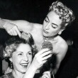 1953. Two photos applying silver to ladies' hair at a nightclub. (Includes press caption.)