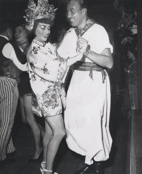 Circa 1954. At a costume party as Anna May Wong, with Cesar Romero.