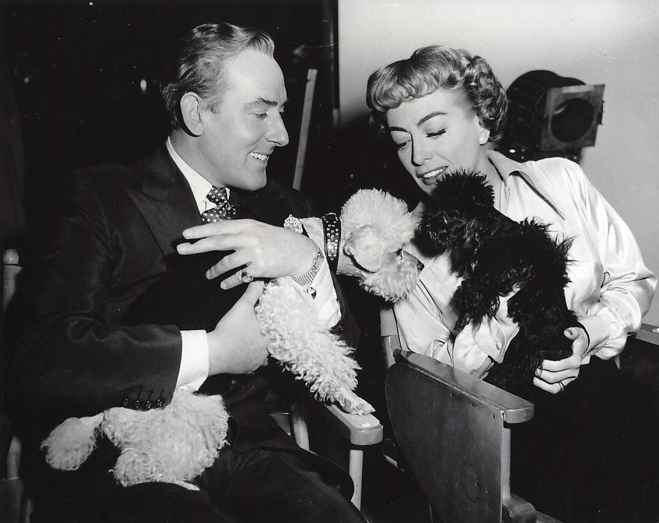 1953. On the set of 'Torch Song' with Michael Wilding and pets.