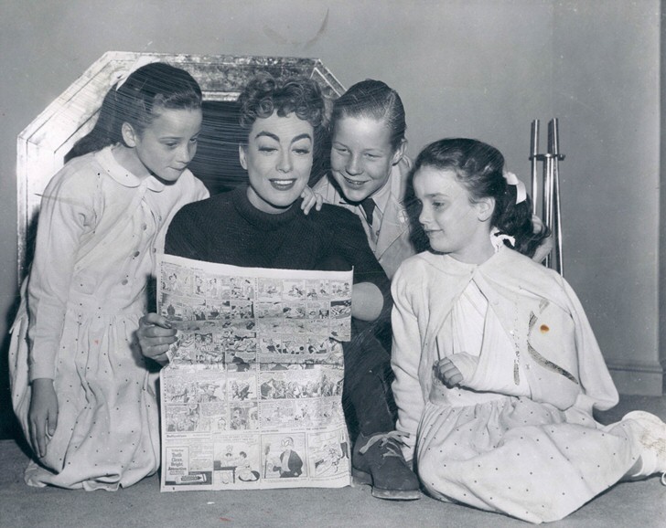 1955. On the set of 'Female on the Beach' with Christopher and twins.