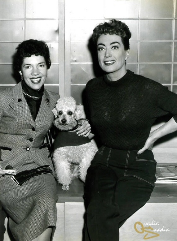 1955 on the set of 'Female on the Beach' with a Brazilian visitor.