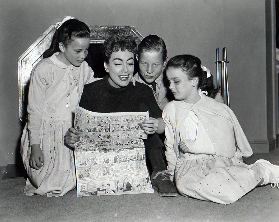 1955. On the set of 'Female on the Beach' with Christopher and The Twins.