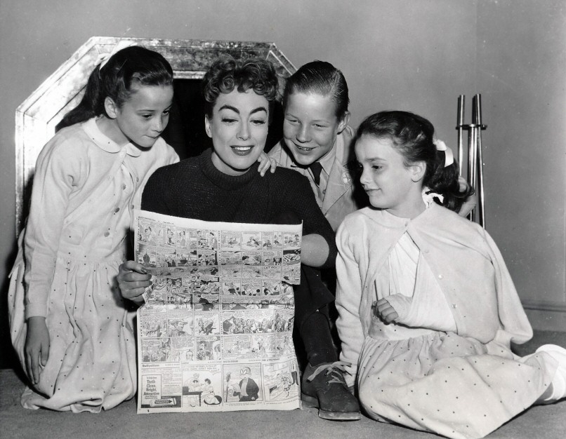 1955. On the set of 'Female on the Beach' with Christopher and the twins.