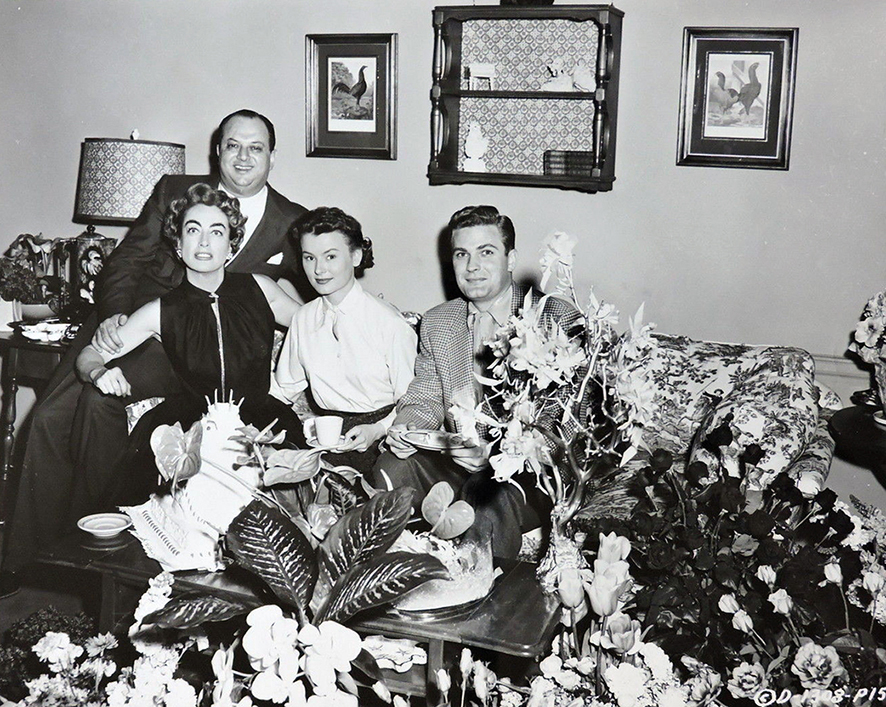 1955. Joan's birthday on the set of 'Queen Bee,' with producer Jerry Wald, Lucy Marlow, and William Leslie.