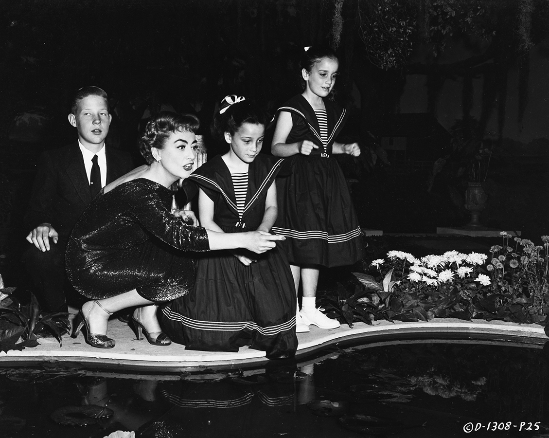 1955. On the set of 'Queen Bee' with Christopher and The Twins.