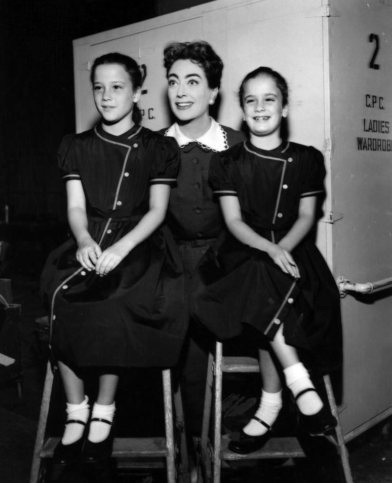 1956 on the set of 'Autumn Leaves' with twins Cathy and Cindy. (Thanks to Crystal.)