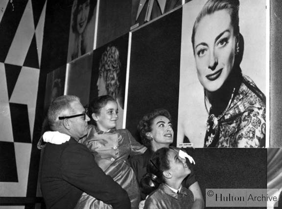 1956. Joan and family look at Joan at the London Film Exhibition.