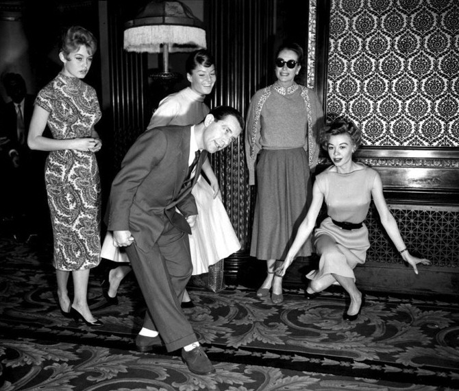 October 28, 1956. The day before being presented to Queen Elizabeth, a curtsy lesson from Norman Wisdom. (With Brigitte Bardot, Belinda Lee, and Vera Ellen.)