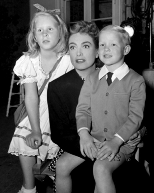 1947. On the set of 'Daisy Kenyon' with kids Christina and Christopher.