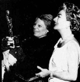 Joan delivers the Oscar to Bancroft on the set of Bancroft's Broadway show 'Mother Courage and Her Children.' May 1963.