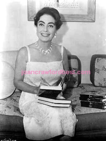 1962. Signing copies of 'Portrait of Joan' on the 'Baby Jane' set.