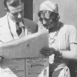 1927. On the set of 'The Unknown' reading a paper with an ad for 'The Understanding Heart.'