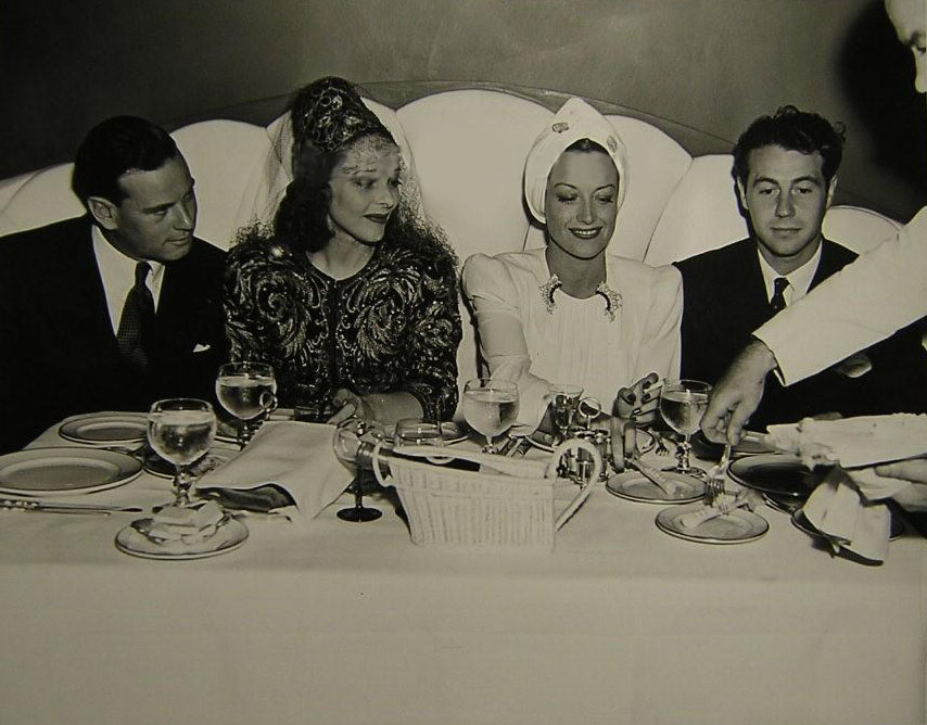 Circa 1939. At Perino's restaurant with director Norman Foster, left, and boyfriend Charles Martin, right.