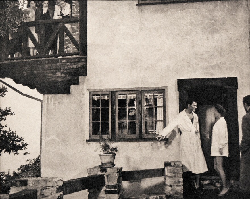 On the set of 'Sudden Fear' in Belvedere, California. The owner of the house and friends are on balcony above watching the scene.