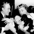 1953. With Michael Wilding and their poodles Cliquot and Titi. Includes press caption.