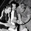 1955. On the set of 'Female on the Beach' with Chandler and Cliquot. Includes press caption.