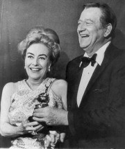 John Wayne presents Joan with the 1969 DeMille award at the '70 Golden Globes